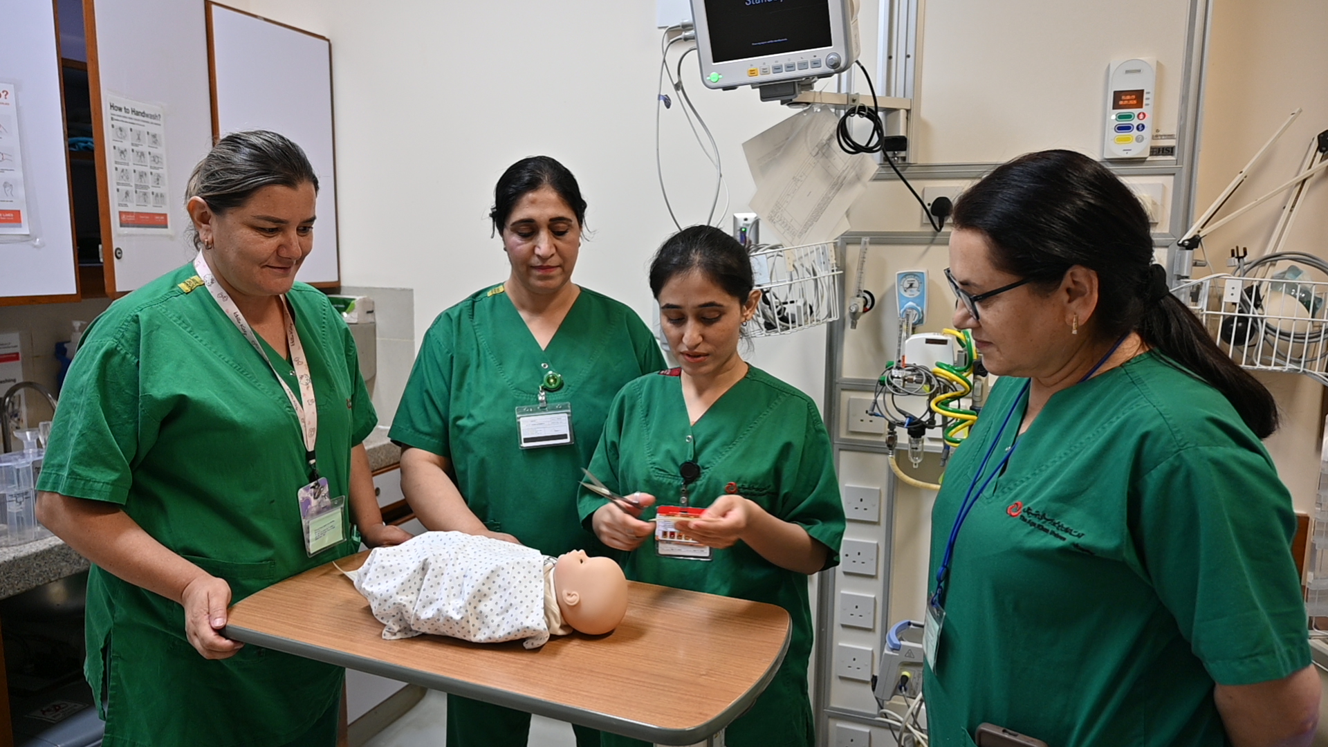 Nurses practise a procedure on a neonatal training manikin