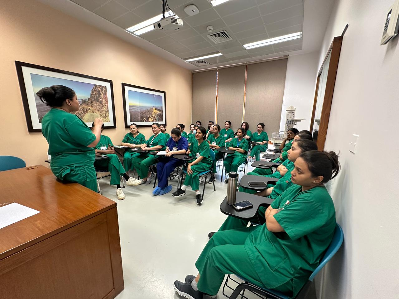 A full classroom in green scrubs